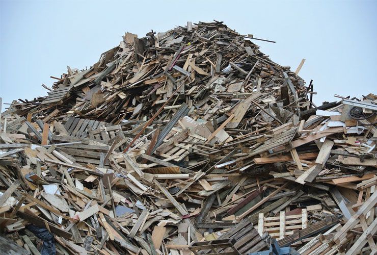 Un tas de bois de récupération se détachant sur un ciel bleu pâle.