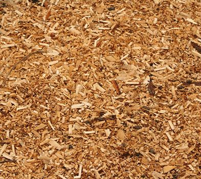 Gros plan sur un tas de copeaux de bois brun clair.