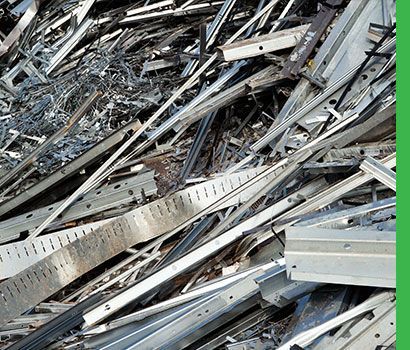 Tas de ferraille, comprenant des poutres et des barres, à l'extérieur.