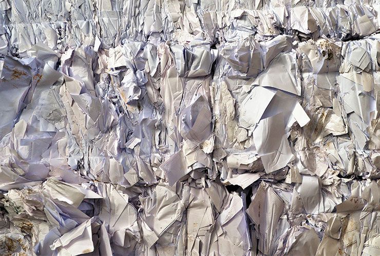 Balle de papier blanc compressé, éventuellement destiné au recyclage, avec des plis et des bords visibles.