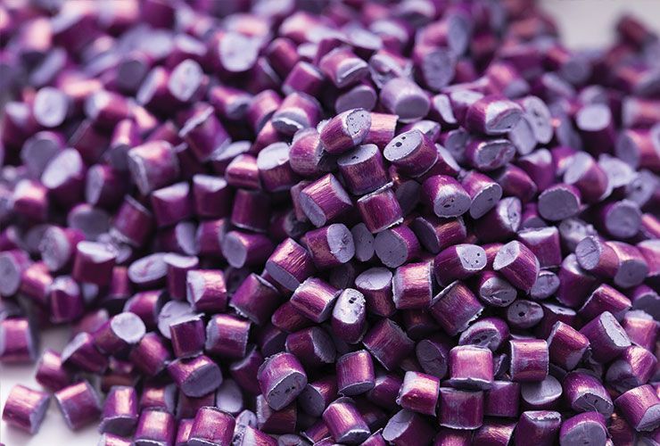 Des granulés de plastique violet empilés les uns sur les autres.