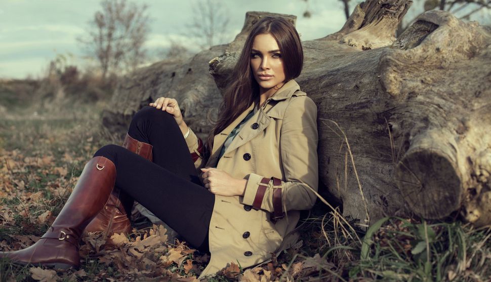Jeune femme avec parka contre un arbre