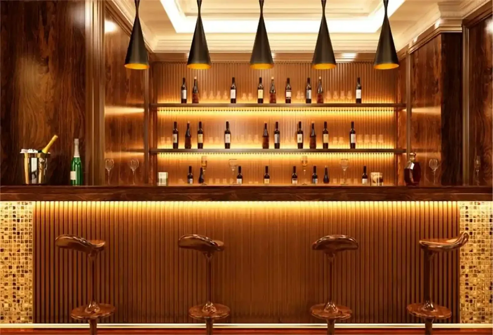 Un bar moderno con cuatro taburetes, una barra revestida de madera, iluminación cálida bajo los armarios.