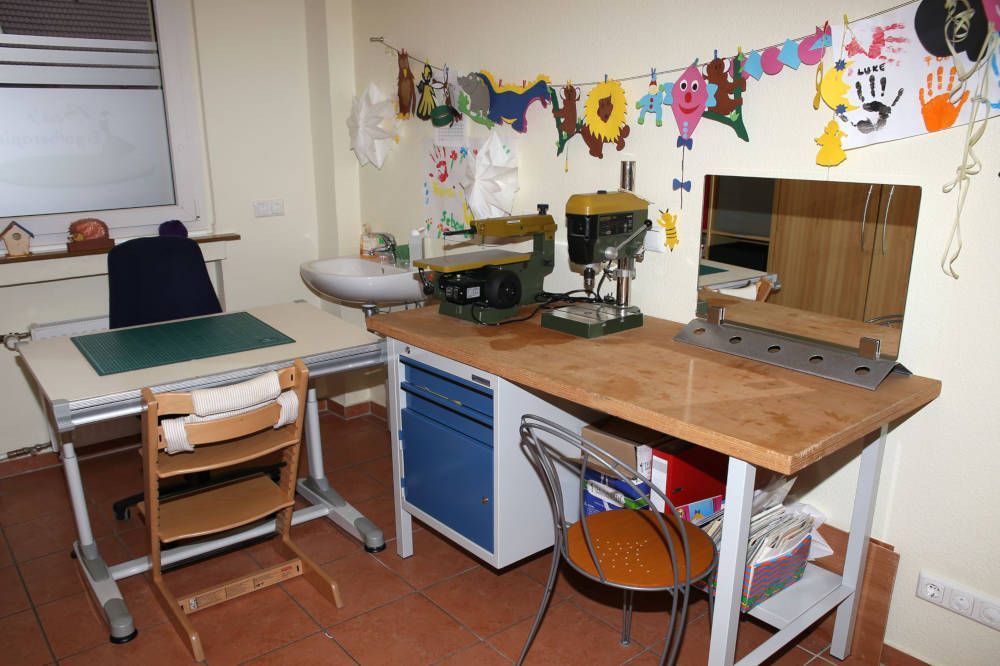 Ein Raum mit einem Tisch und Stühlen und einem Spiegel