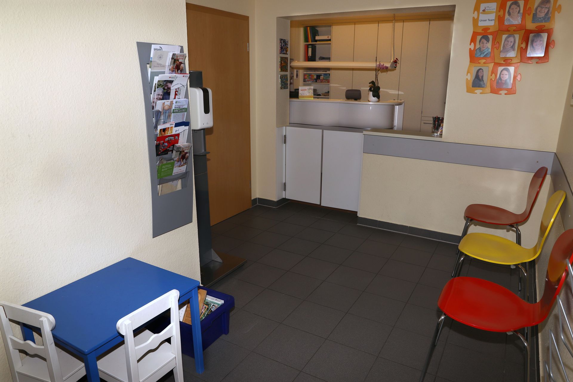 Ein Wartezimmer mit einem blauen Tisch und weißen Stühlen