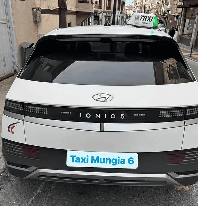 Un coche blanco con un cartel de taxi encima.