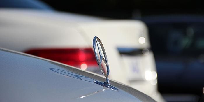 Eine Nahaufnahme eines Mercedes-Logos auf der Motorhaube eines Autos