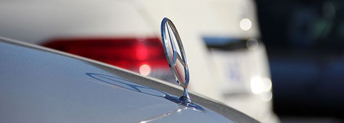 Eine Nahaufnahme eines Mercedes-Emblems auf der Motorhaube eines Autos