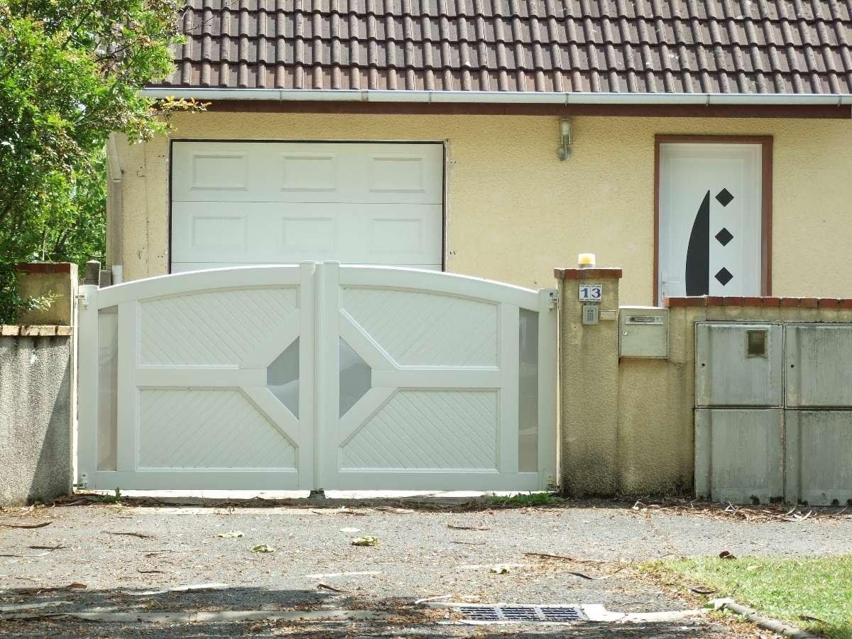 Portail blanc fermé devant maison