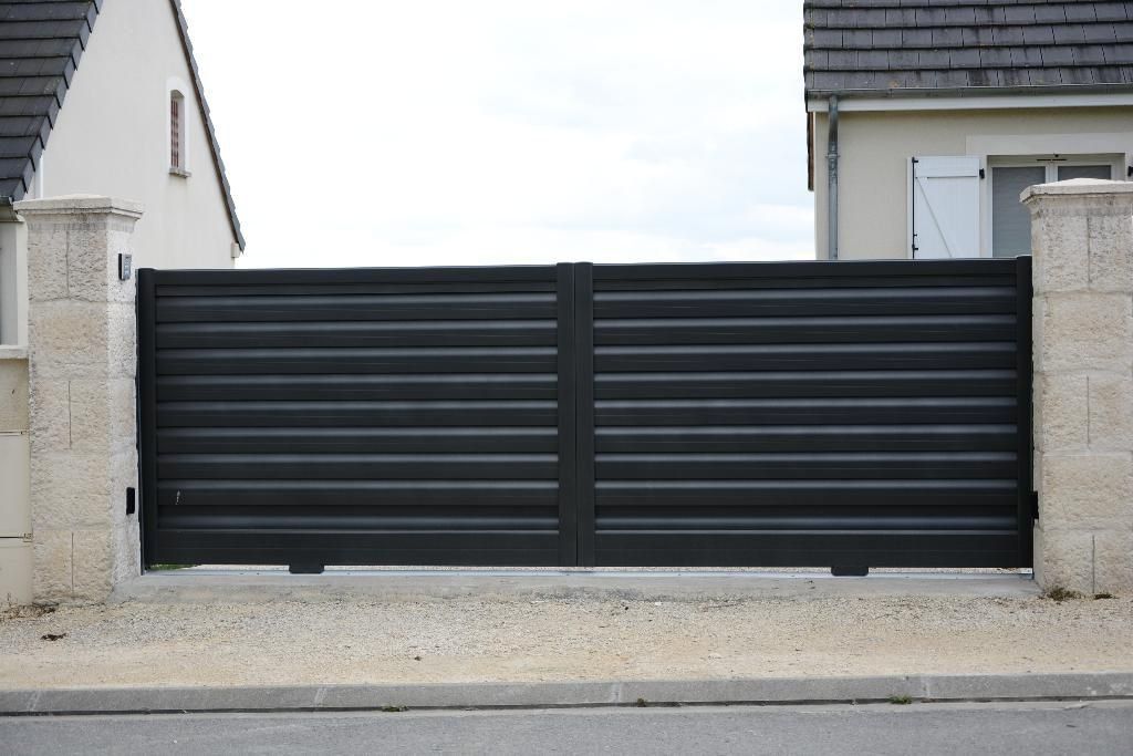 Portail noir devant maisons