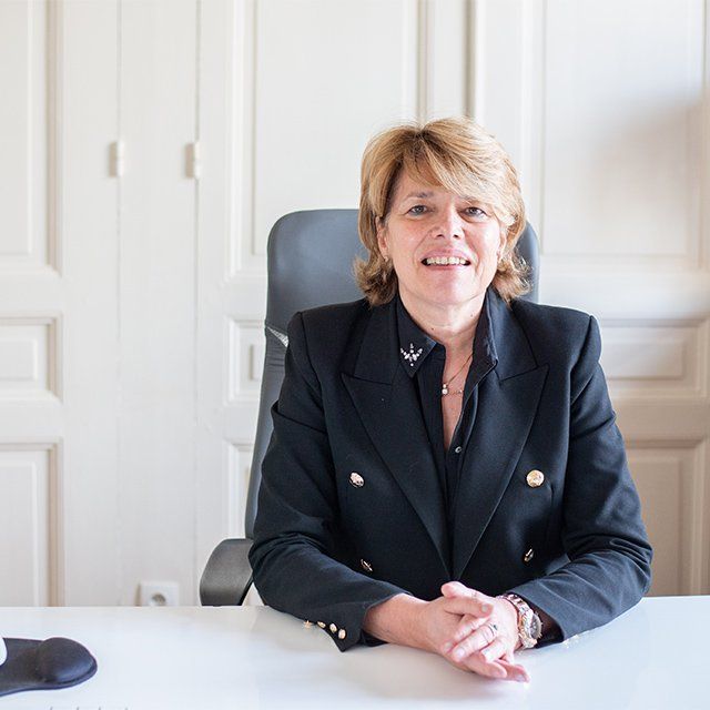 Maître GAUCHER assise devant son bureau.