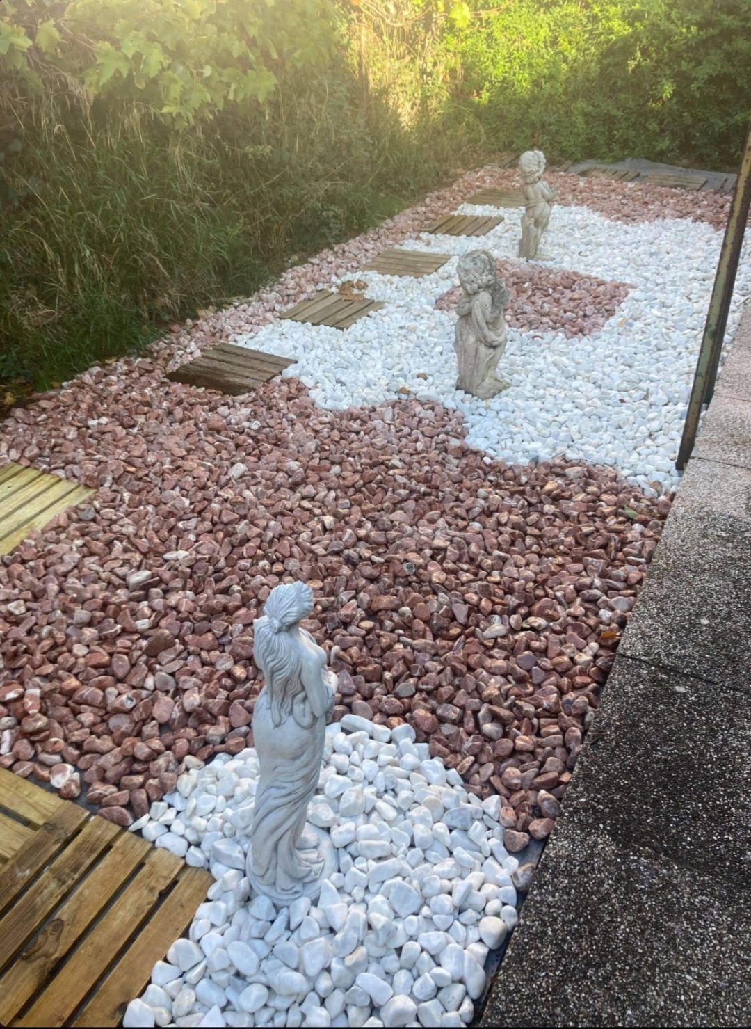 Pose de graviers rouge et blanc avec des statues