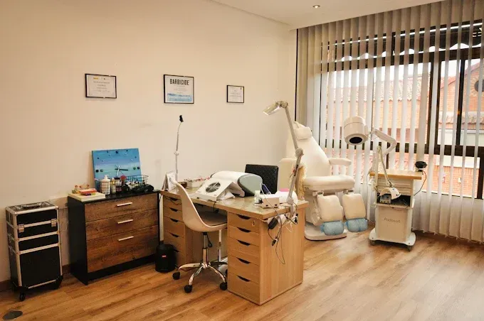 Consultorio médico con silla dental, escritorio y equipo cerca de una ventana.