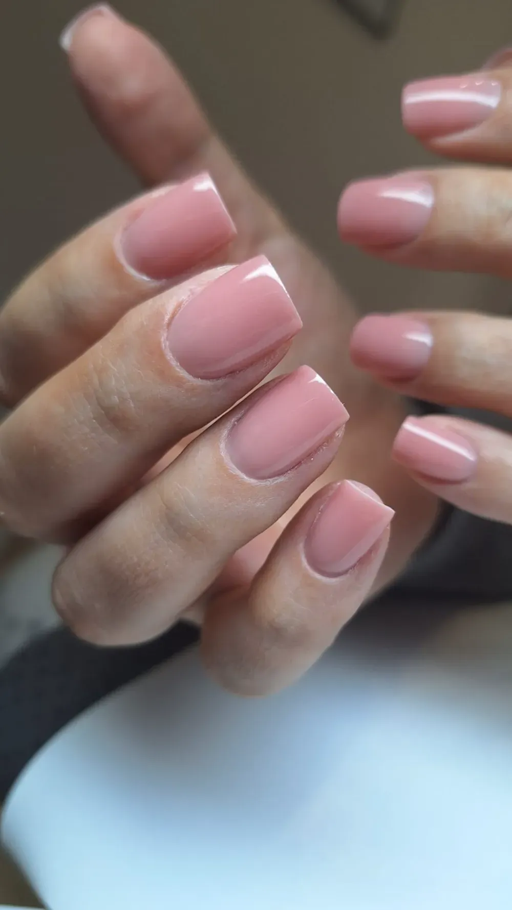 Manos con uñas cuidadas, cuadradas y de color nude.