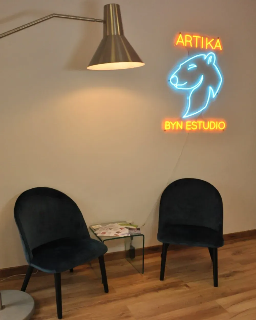 Dos sillas se encuentran frente a un cartel de neón de