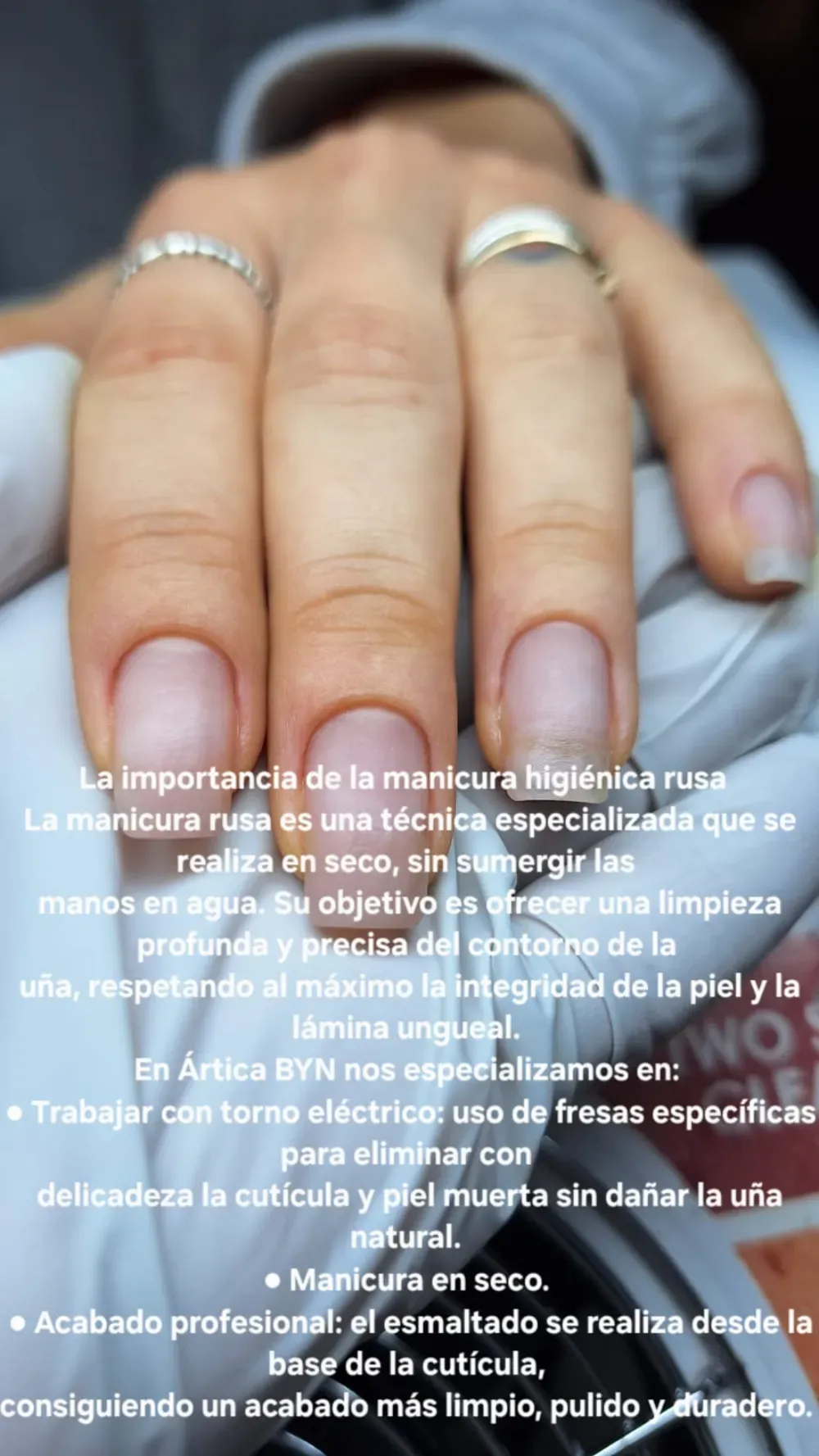 Primer plano de una mano con esmalte de uñas transparente y texto sobre la técnica de manicura rusa.