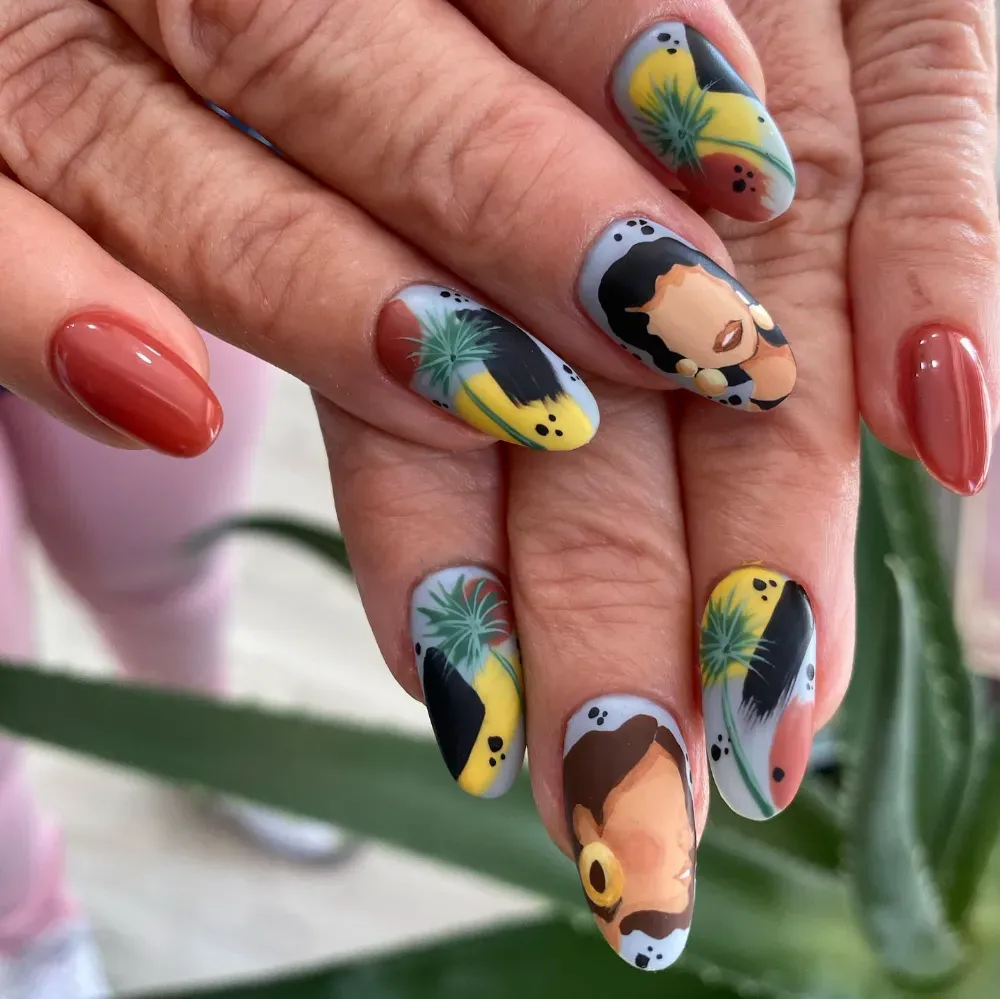 Mano con uñas pintadas de forma ovalada: color sólido de color óxido y arte abstracto con rostros.