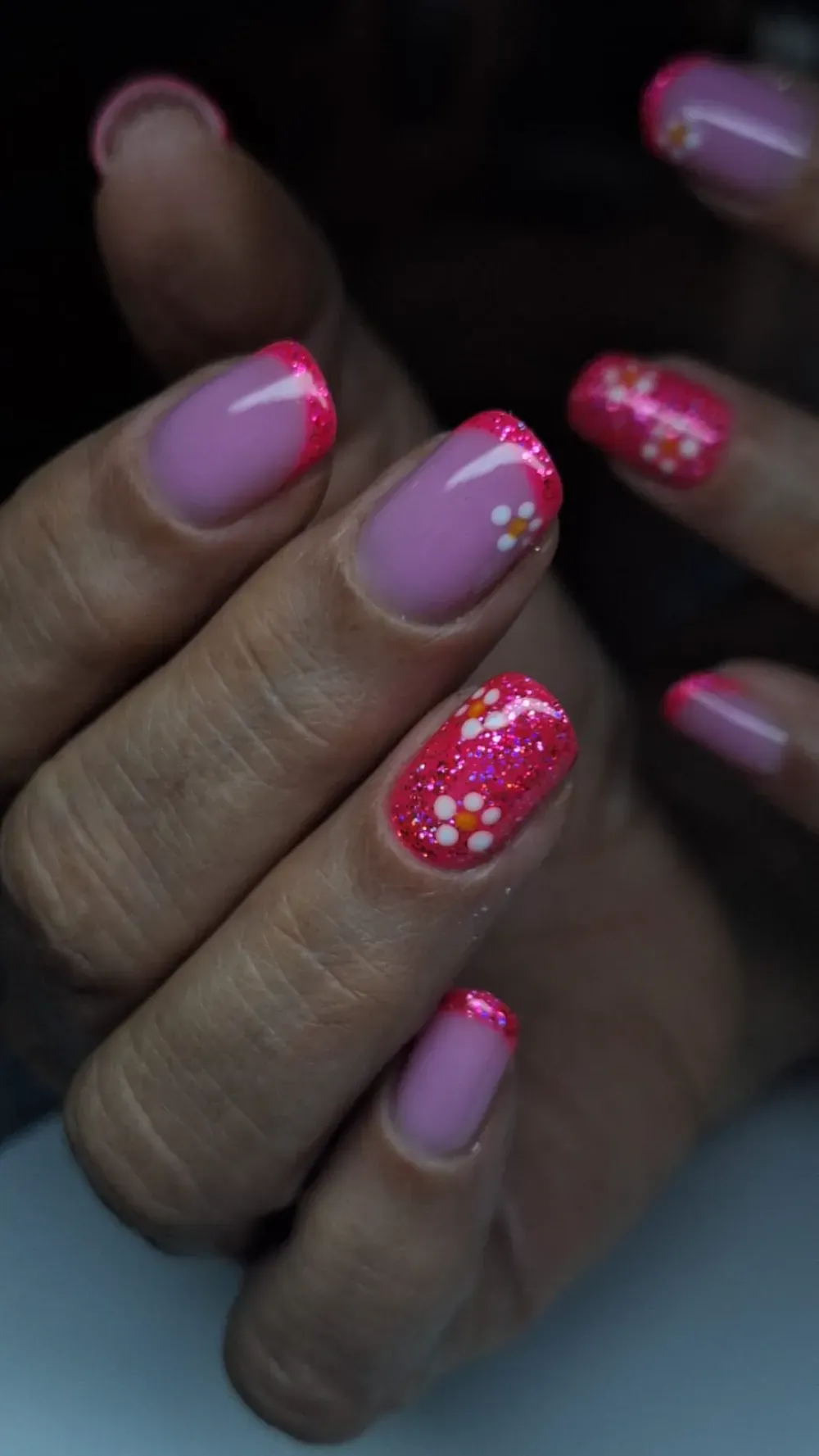Manicura francesa rosa con acentos florales.