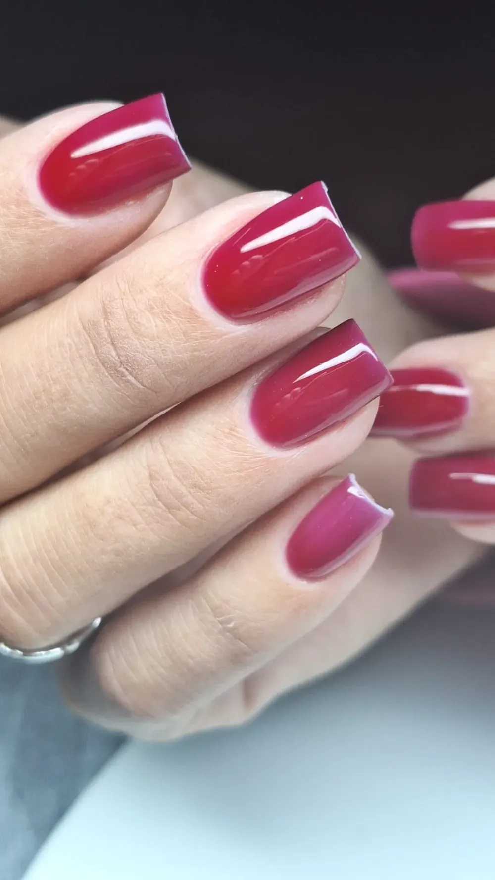 Manos con uñas cuadradas pintadas de un rojo brillante.