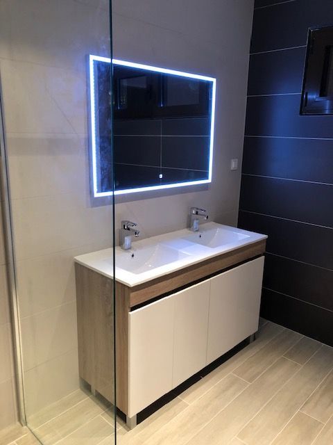 Pose d'un meuble et d'un miroir dans une salle de bains