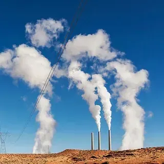 Sale humo de tres chimeneas en el desierto.