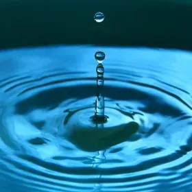 Una gota de agua está cayendo en un charco de agua.