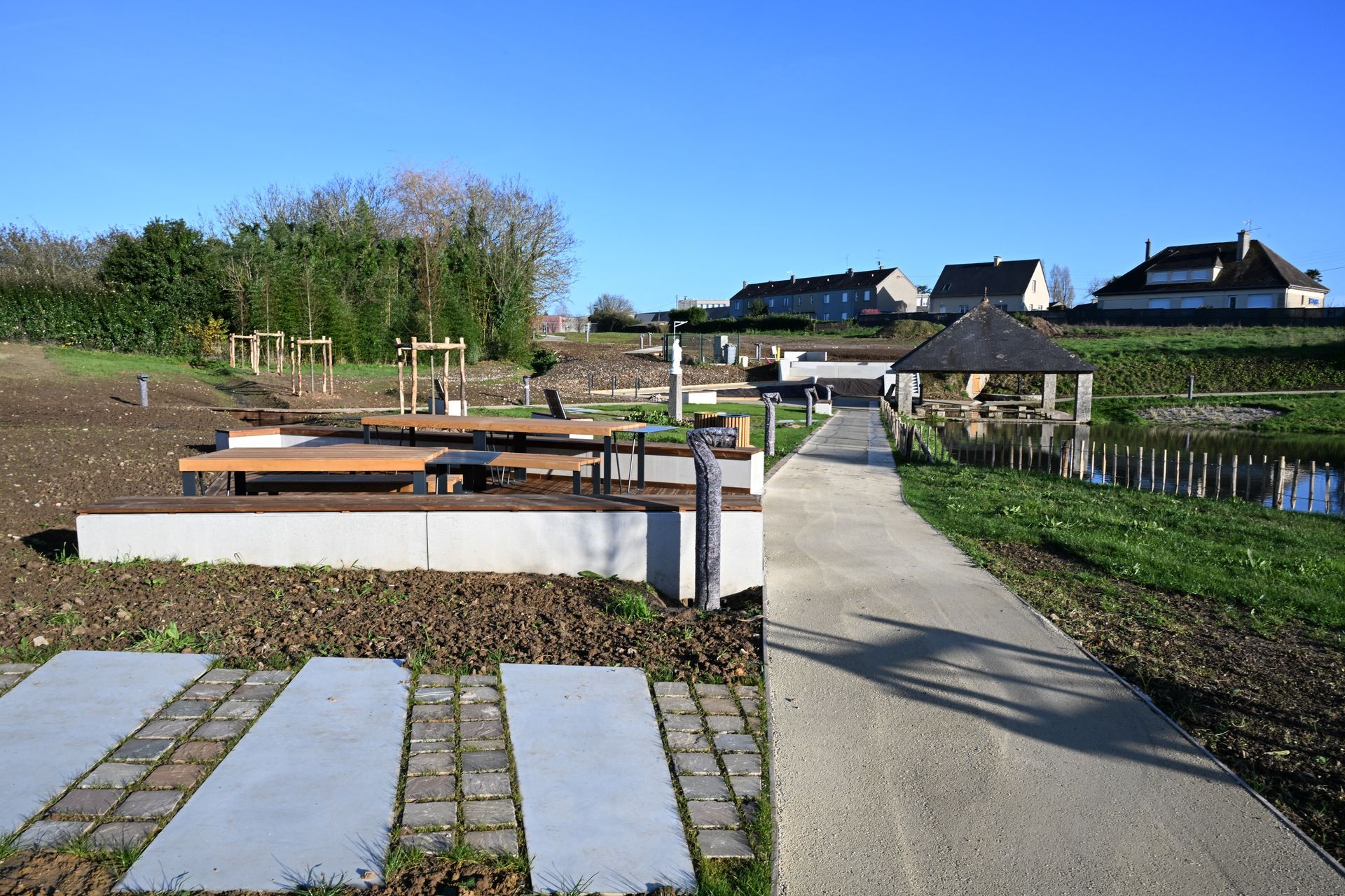 Allée aménagée avec grande dalle de béton dans un parc
