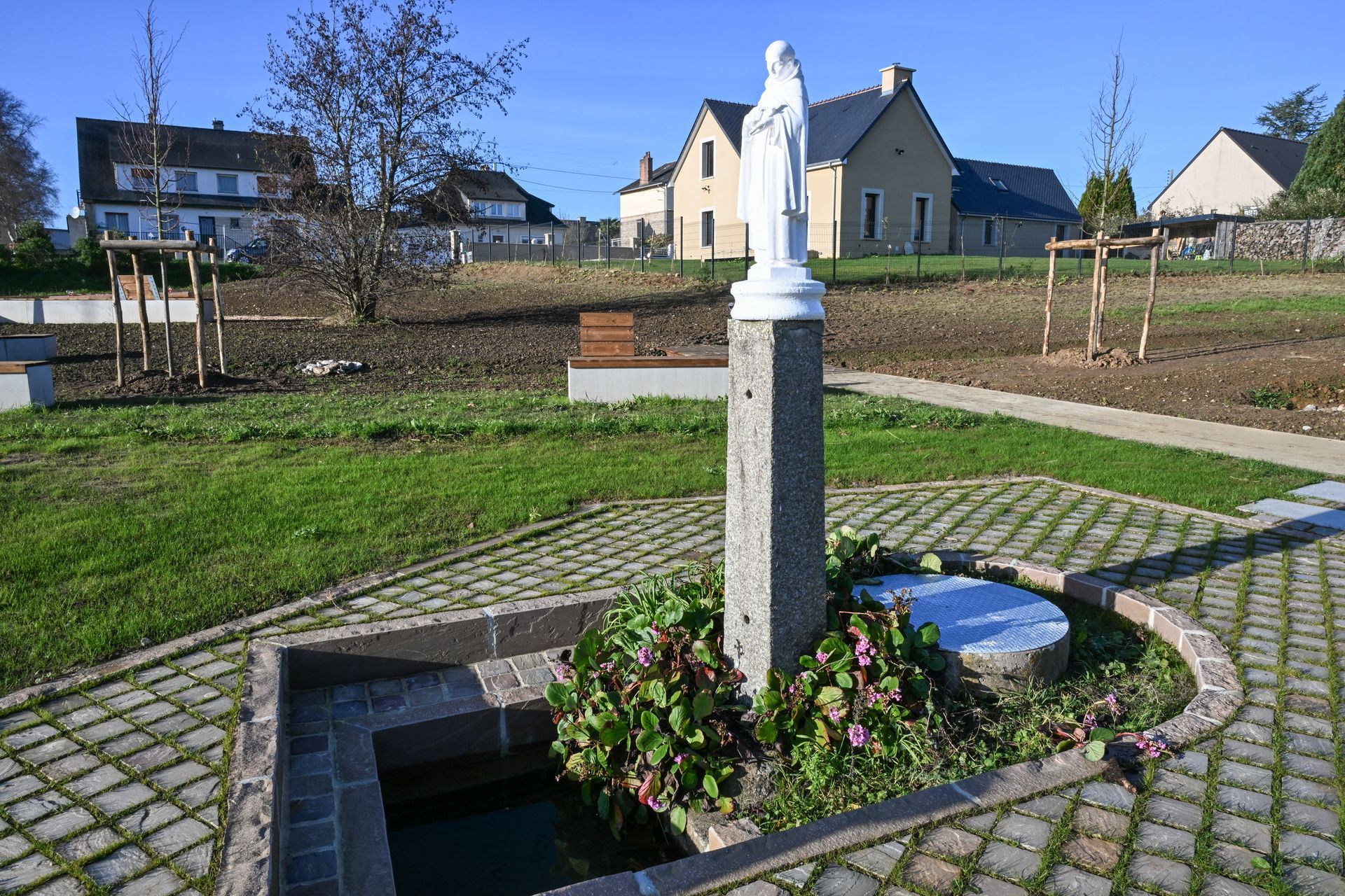 Statue de la Vierge Marie au milieu d'un parc à Sainte-Mère-Église