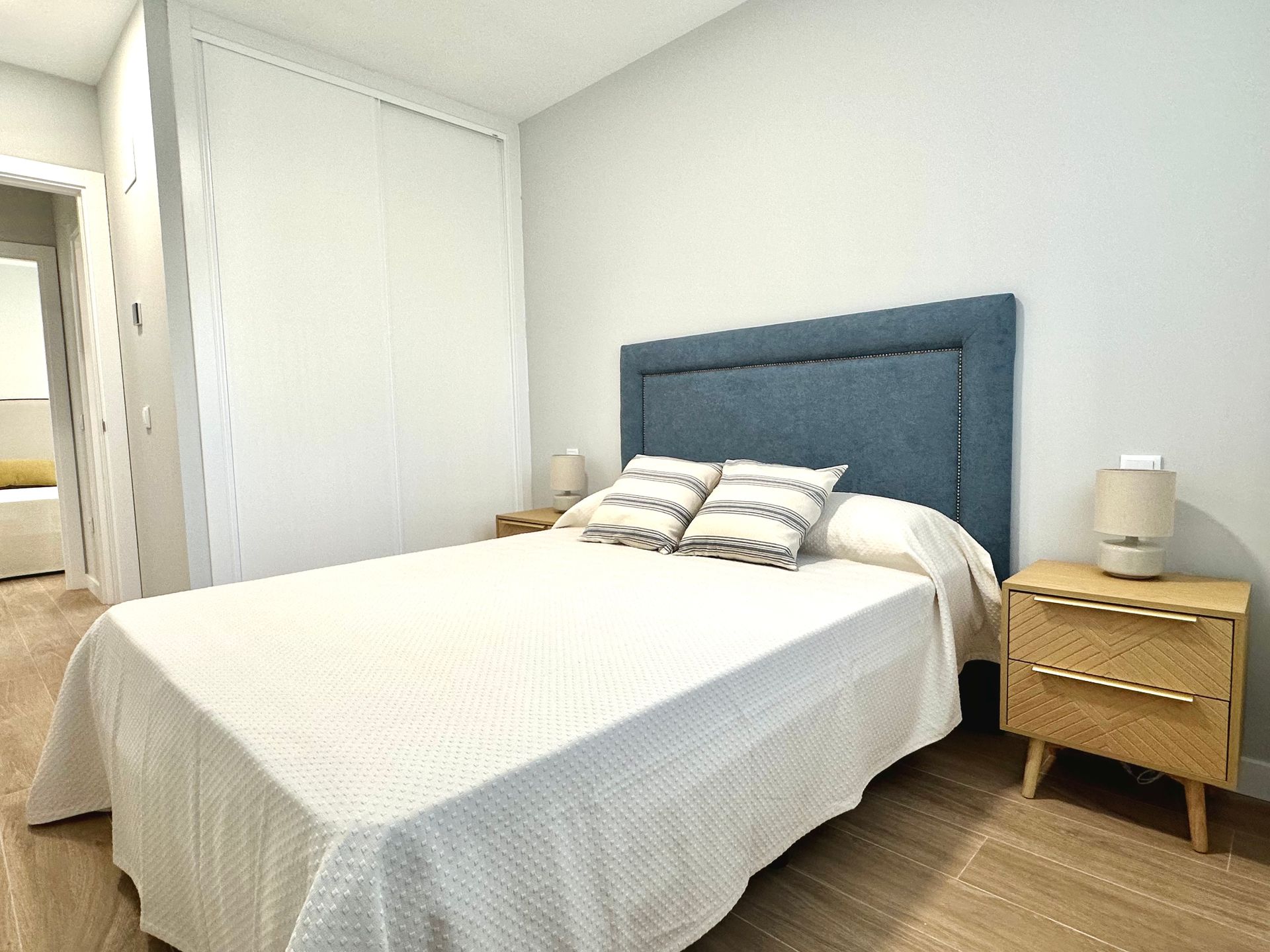 A bedroom with a large bed and two nightstands.