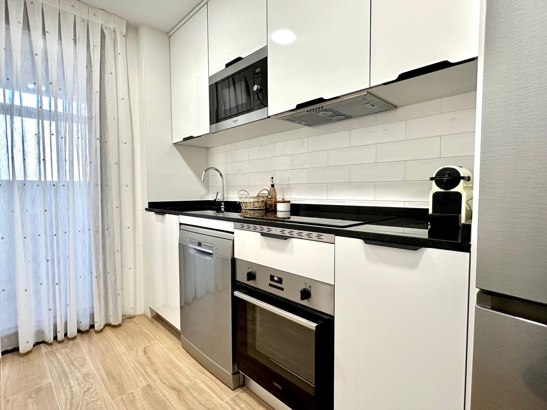 A kitchen with white cabinets and stainless steel appliances.