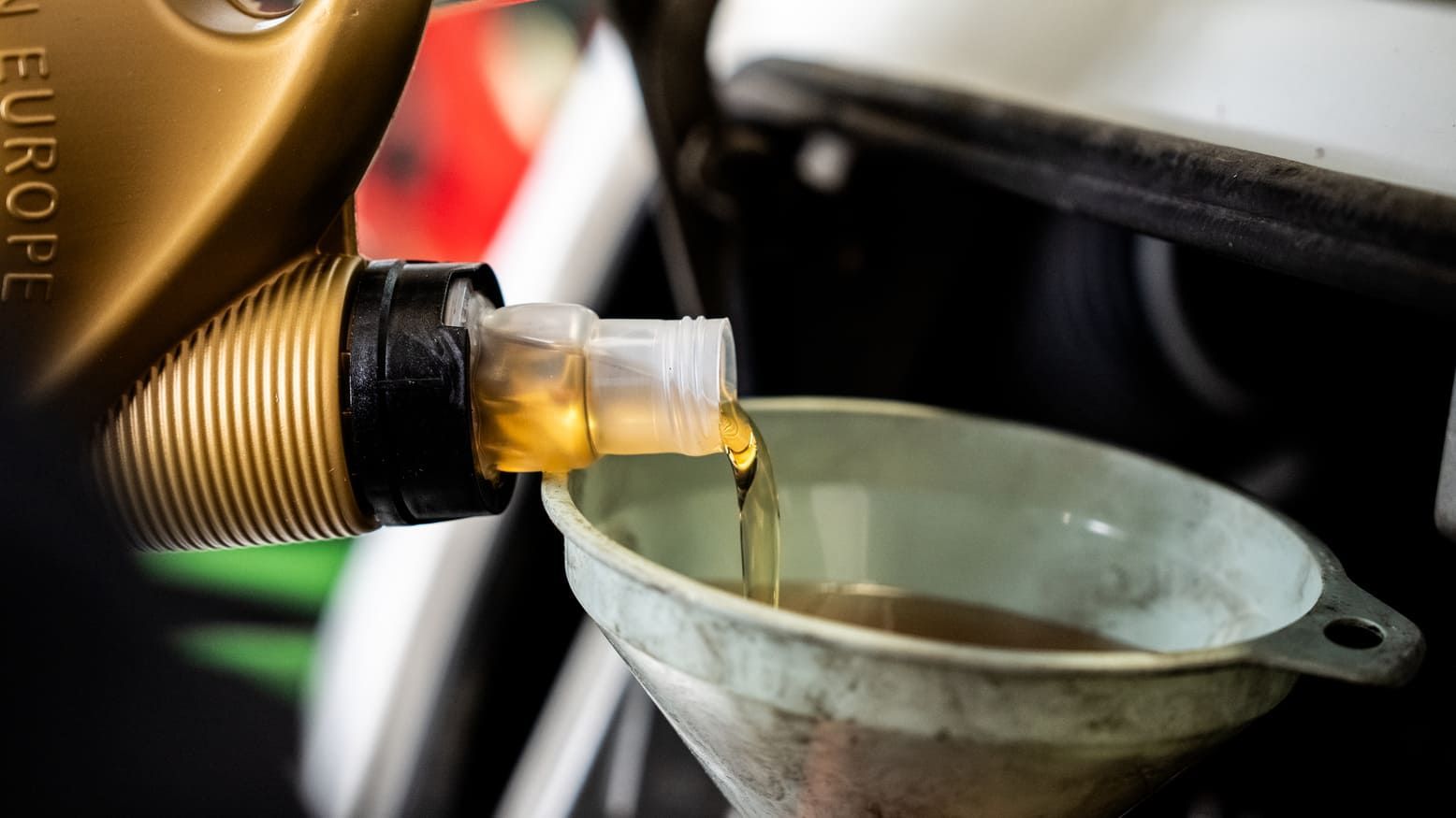Una persona está vertiendo aceite en un embudo.