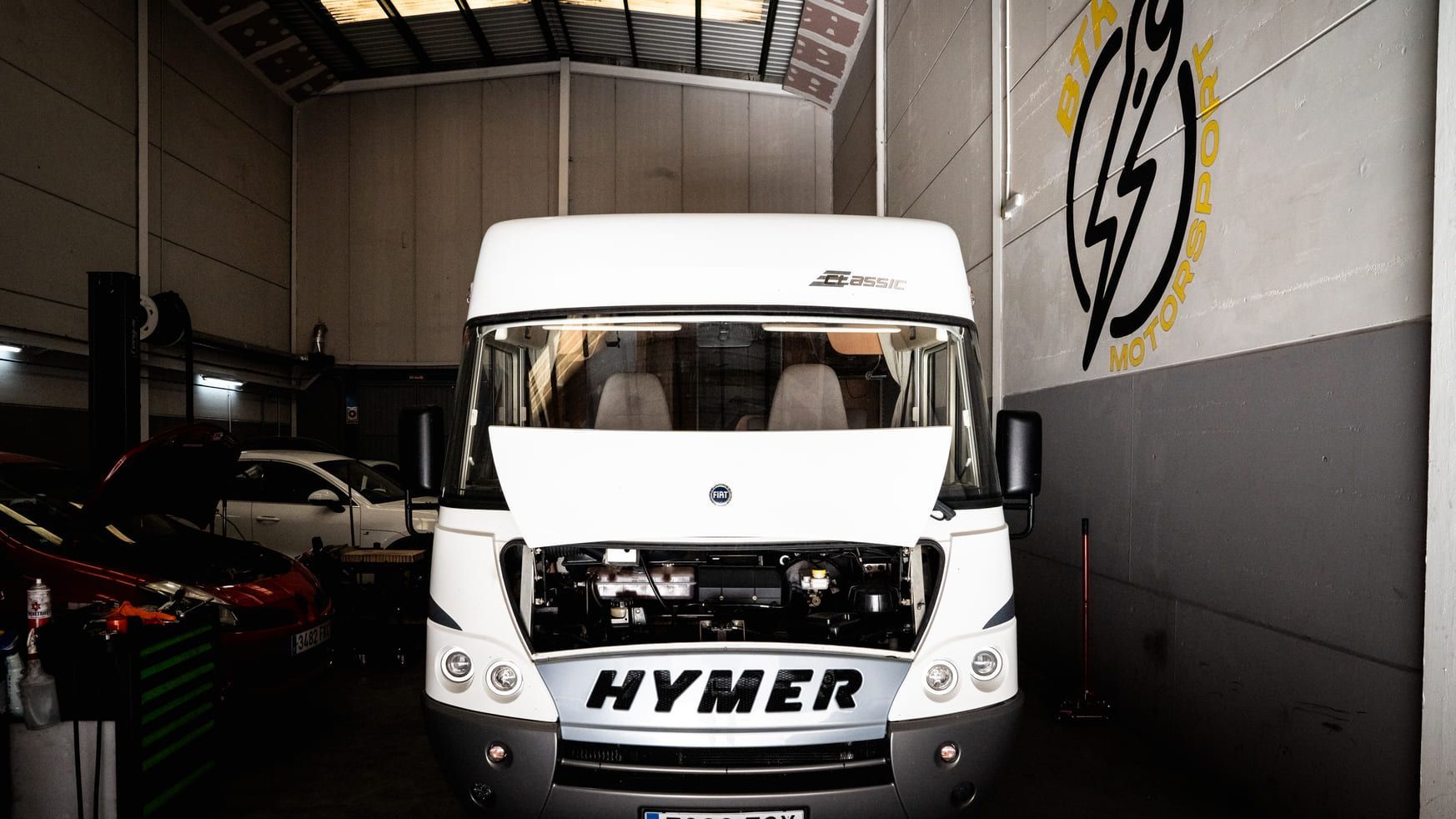 Una autocaravana Hymer de color blanco está aparcada en un garaje.