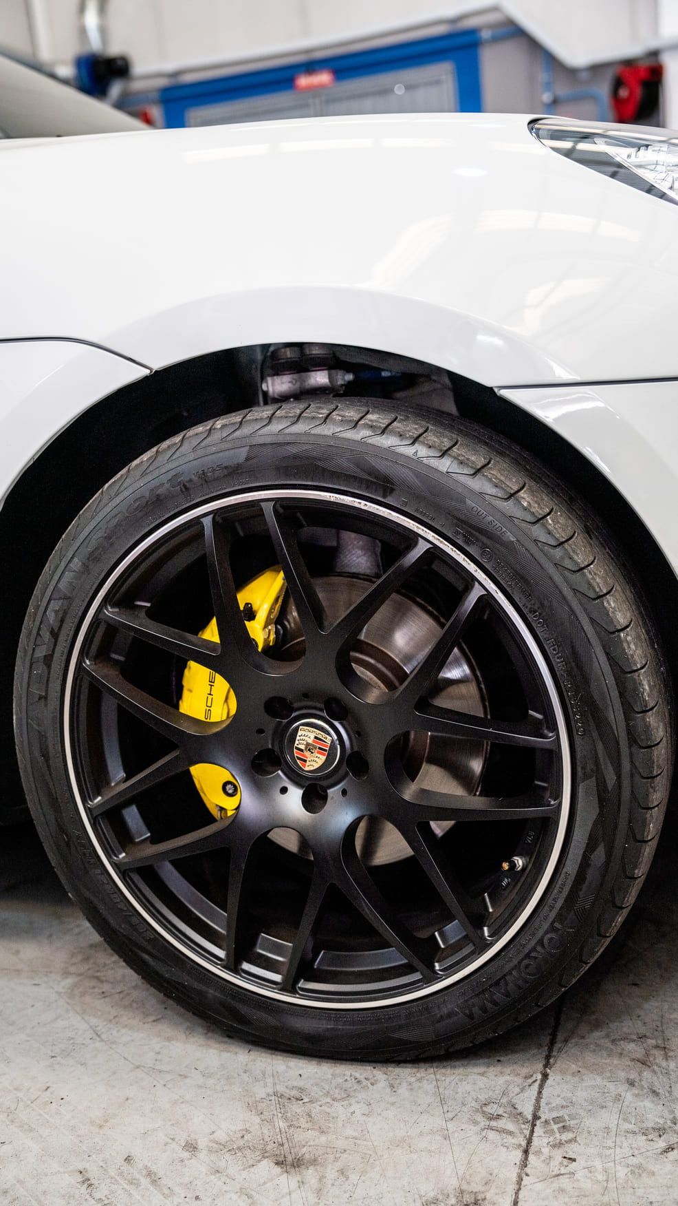 Un primer plano de una rueda de automóvil con pinzas de freno amarillas.