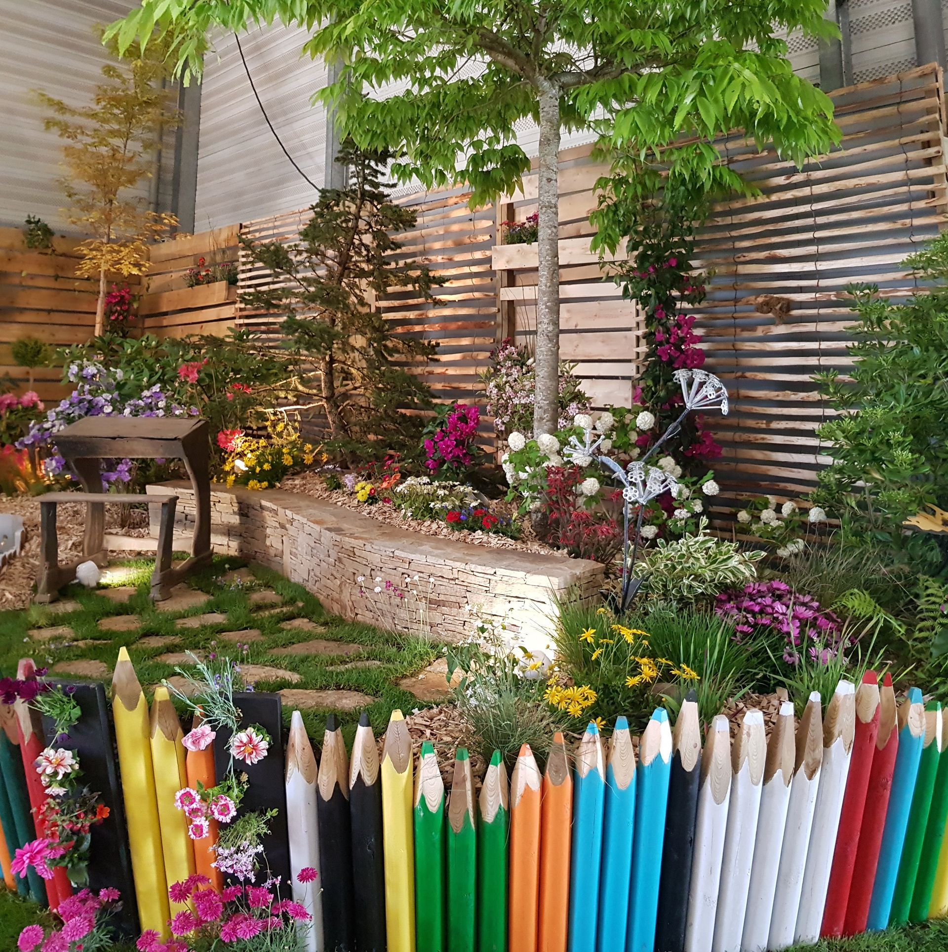 Un jardin fleuri et une clôture en bois.