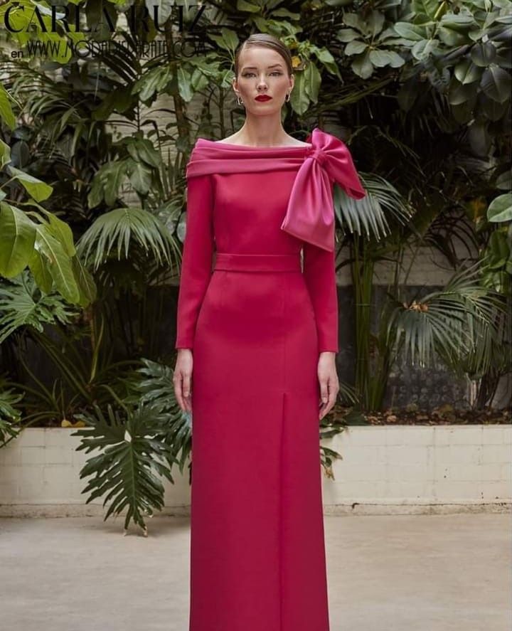 Una mujer lleva un vestido largo rosa con un lazo en el lateral.