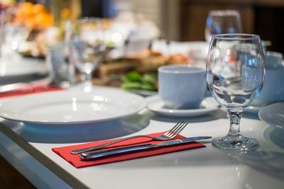Una mesa puesta para una comida con platos, cubiertos y una copa de vino.