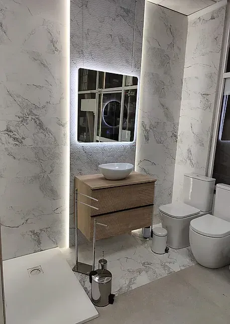 Un baño con lavabo, inodoro y espejo.