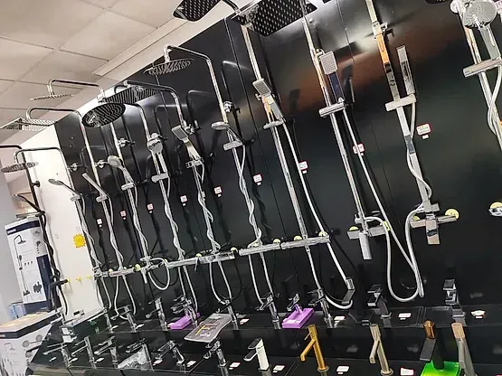 Una fila de cabezales de ducha están alineados en una pared en una tienda.