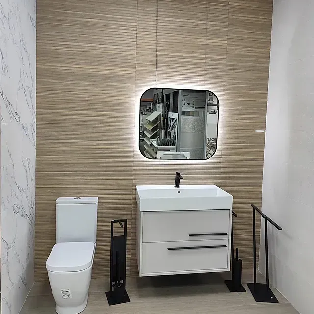 Un baño con inodoro, lavabo y espejo.