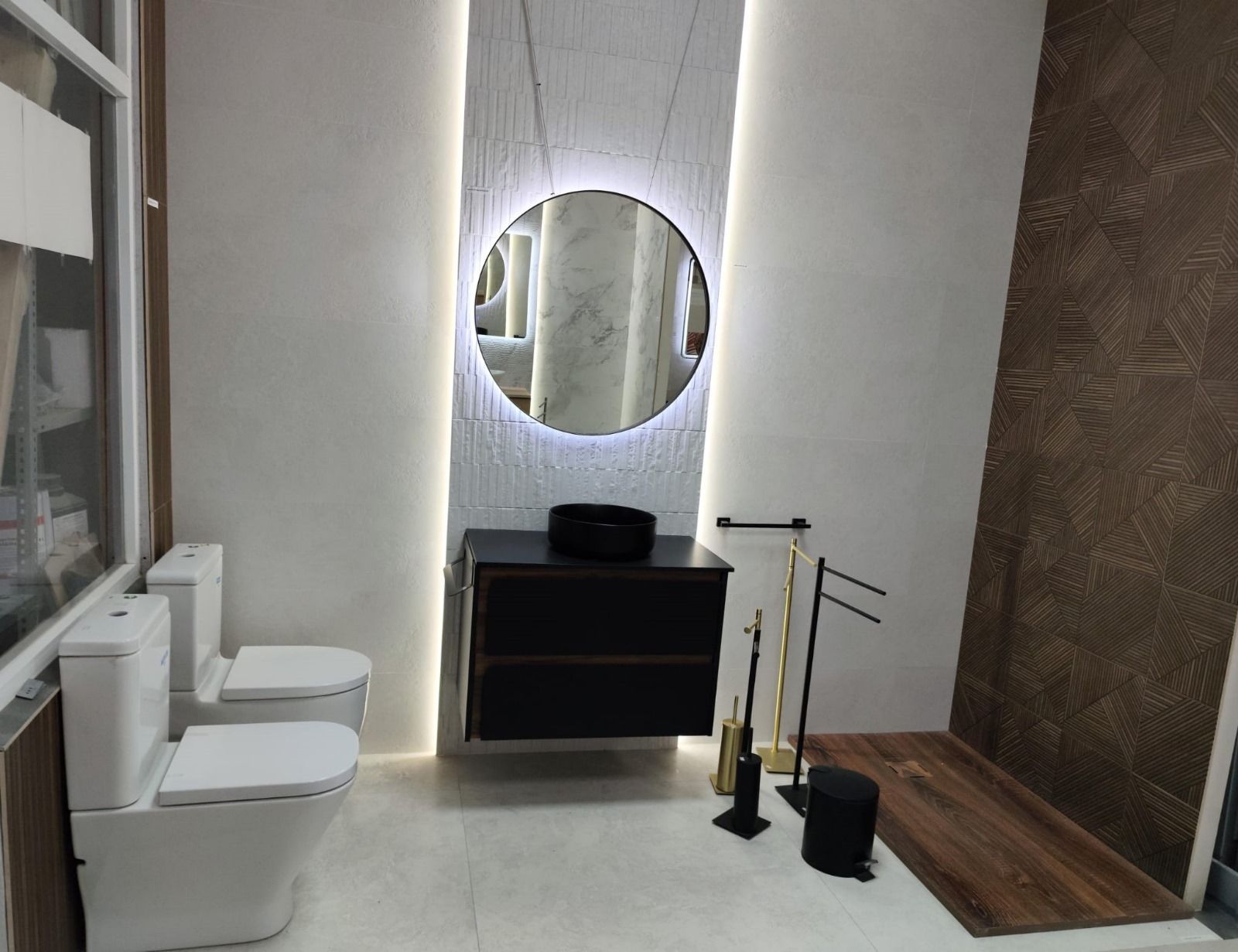 Un baño con dos inodoros, un lavabo y un espejo.