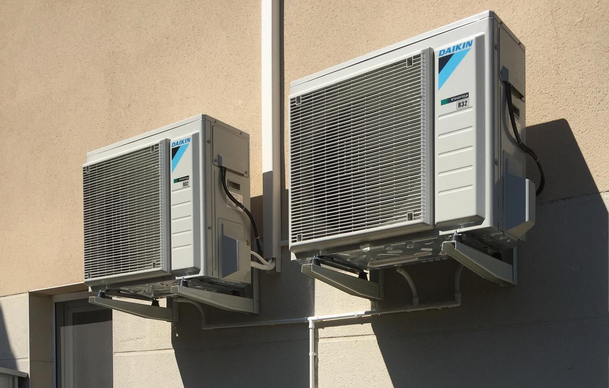 Groupe de pompes à chaleur en hauteur sur un mur