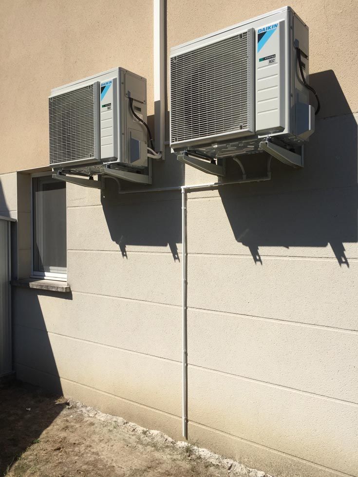Pompes à chaleur installées sur un mur extérieur en hauteur