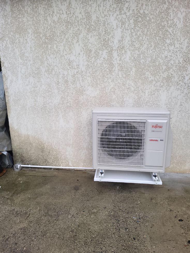 Pompe à chaleur sur un mur gris