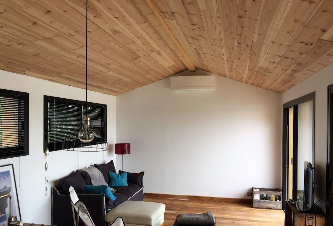 Pompe à chaleur air air dans une pièce de vie avec un canapé noir