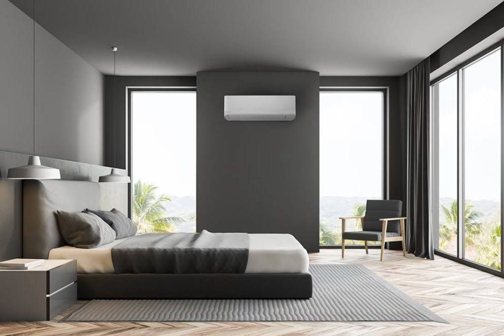 Pompe à chaleur à l'intérieur d'une chambre à coucher aux murs gris foncés