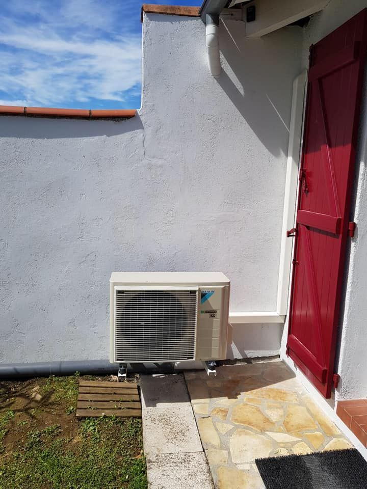 Pompe à chaleur près d'une fenêtre avec un volet rouge