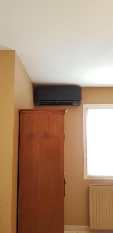 Climatisation dans une chambre avec une armoire en bois