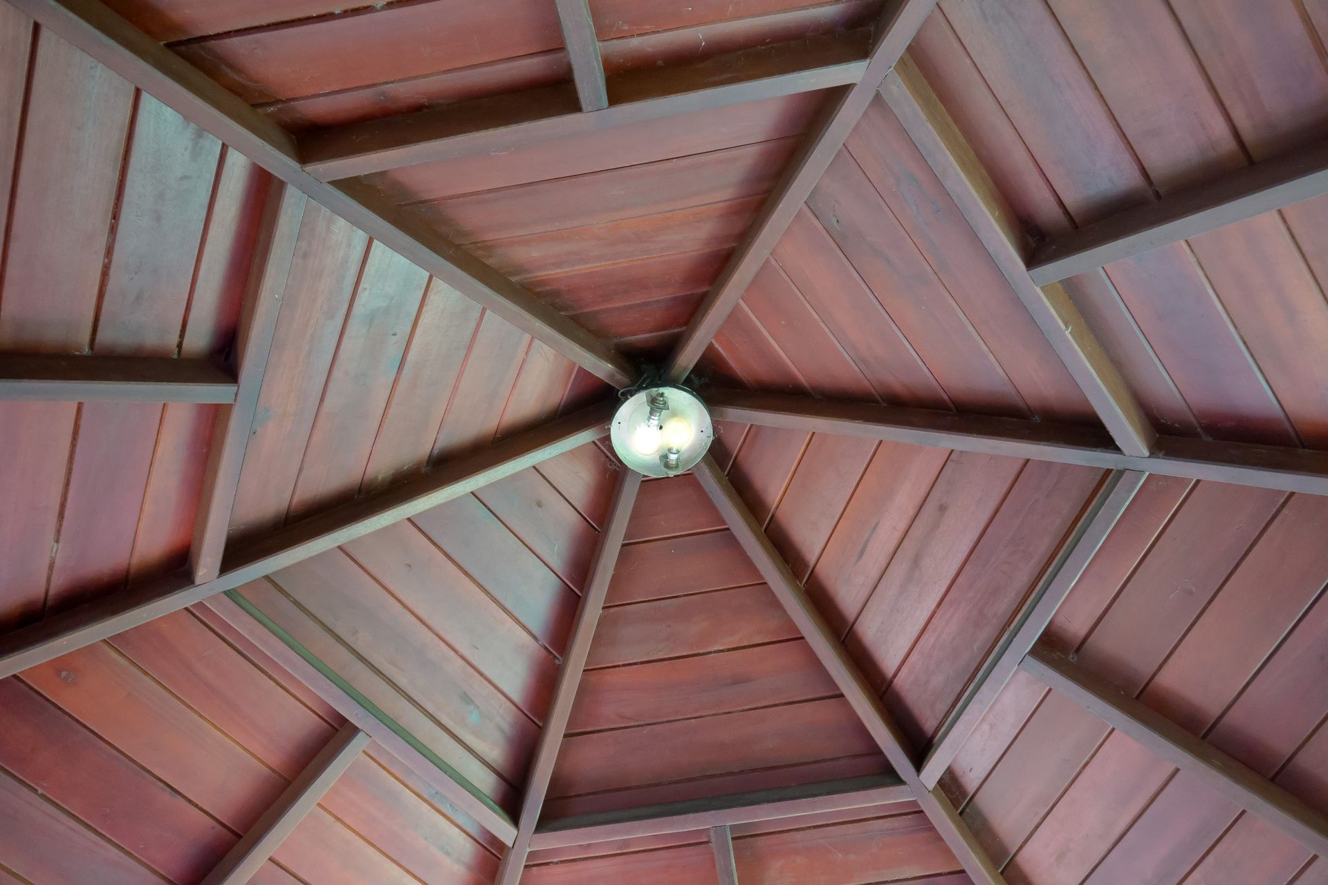 Un techo de madera con una luz colgando de él.