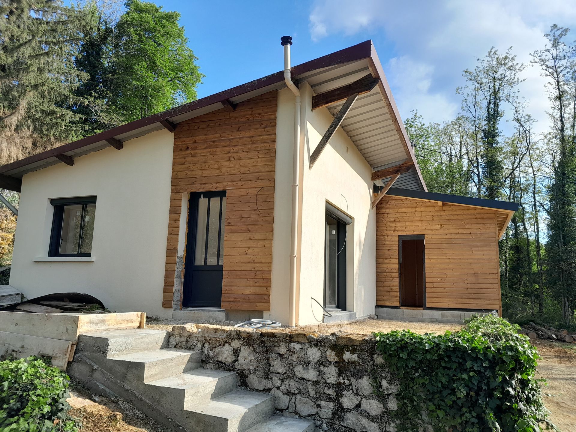 Façade d'une maison avec de l'enduit et du bardage en bois.