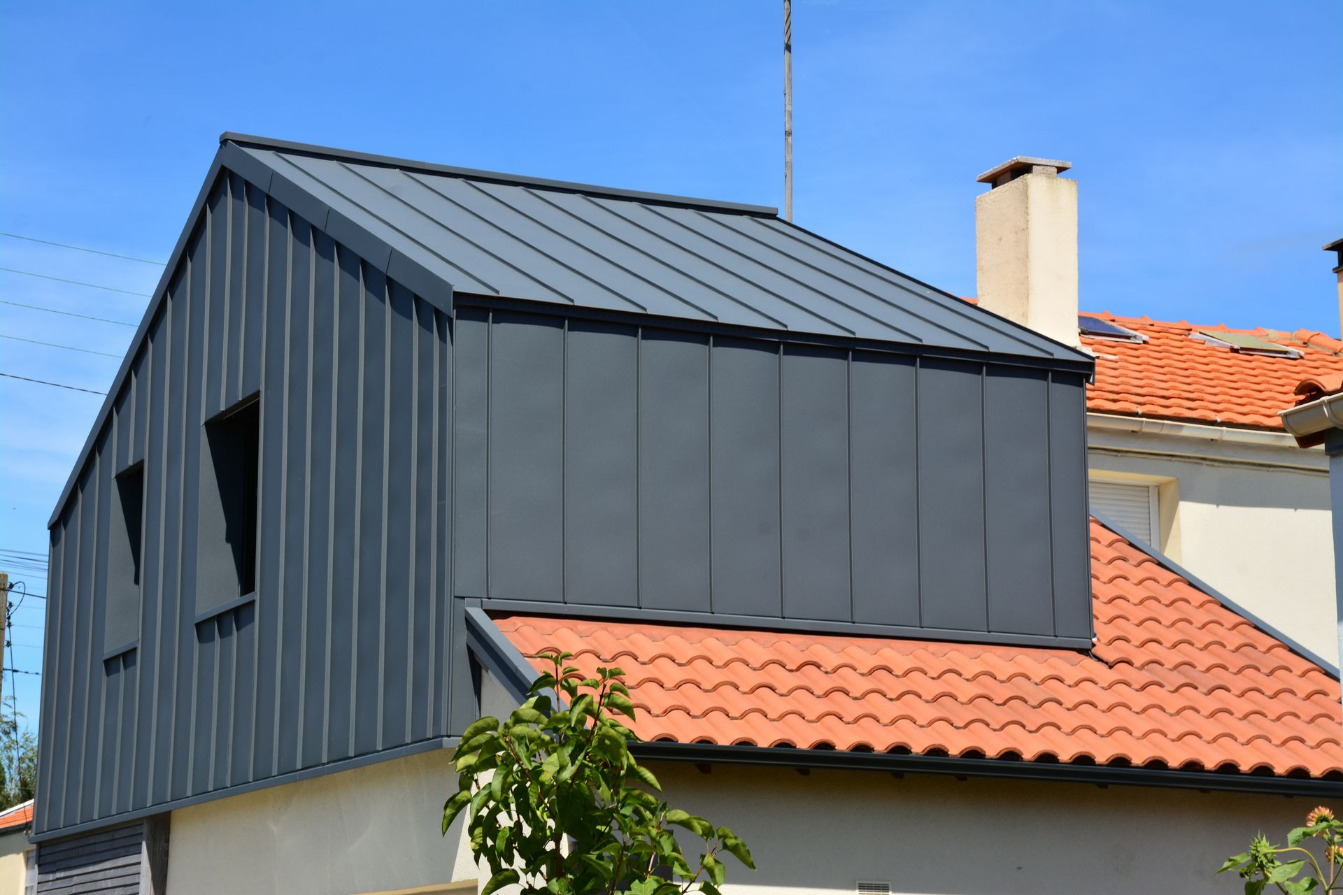 Surélévation d'une maison en toit bac acier et bardage métallique.